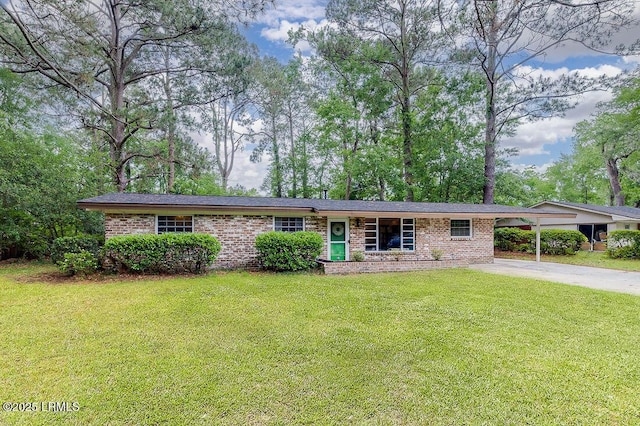 ranch-style house with brick siding, driveway, a front yard, and a carport