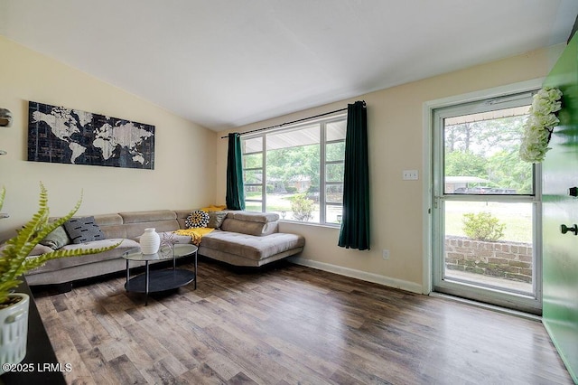 living room featuring wood finished floors, vaulted ceiling, and baseboards