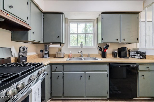 kitchen with stainless steel range with gas cooktop, black dishwasher, a sink, under cabinet range hood, and gray cabinetry