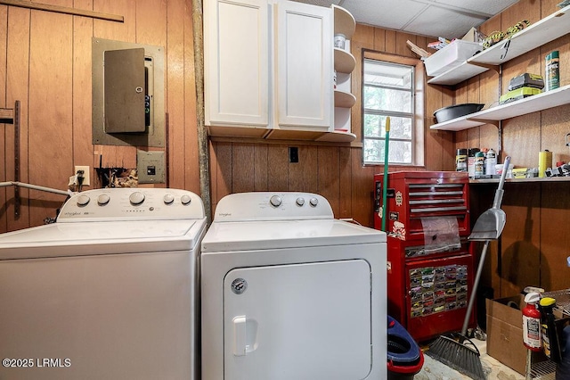 laundry area with cabinet space, washer and dryer, and wooden walls