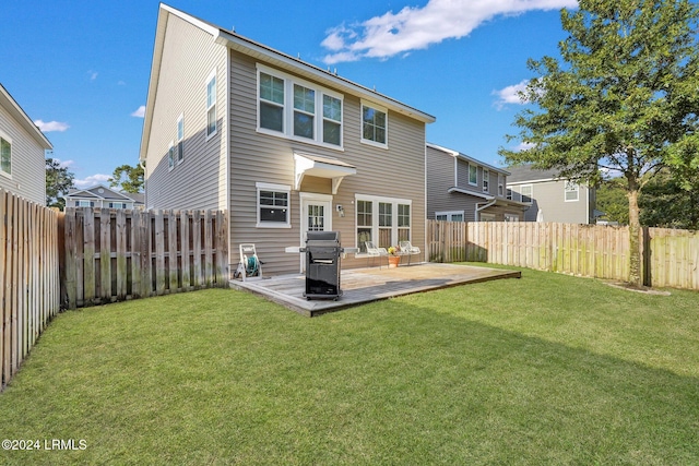 rear view of house featuring a wooden deck and a yard