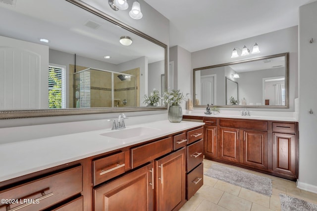 bathroom with tile patterned flooring, vanity, and a shower with shower door