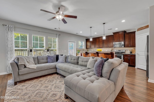 living room featuring hardwood / wood-style flooring and ceiling fan