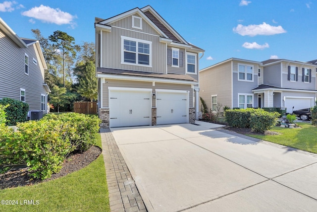 view of front of home featuring cooling unit, a garage, and a front yard