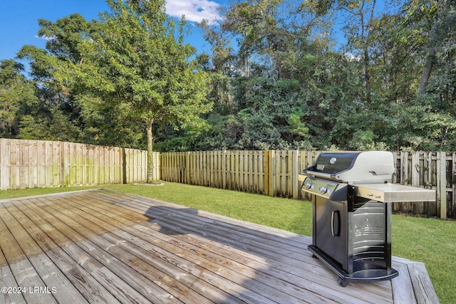 wooden terrace featuring grilling area and a lawn