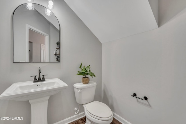 bathroom featuring lofted ceiling, sink, and toilet