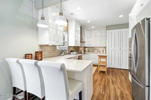 39 Barrington Ave, Bluffton, SC 29910 - kitchen with a kitchen breakfast bar, stainless steel appliances, a sink, a peninsula, and glass insert cabinets