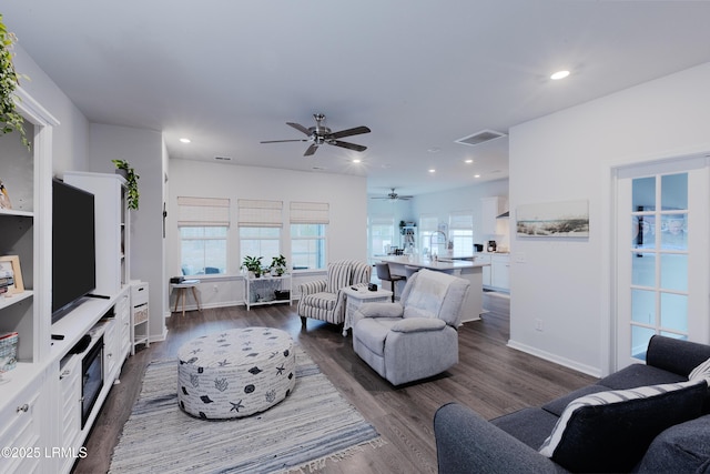 living room featuring ceiling fan, dark hardwood / wood-style flooring, and sink