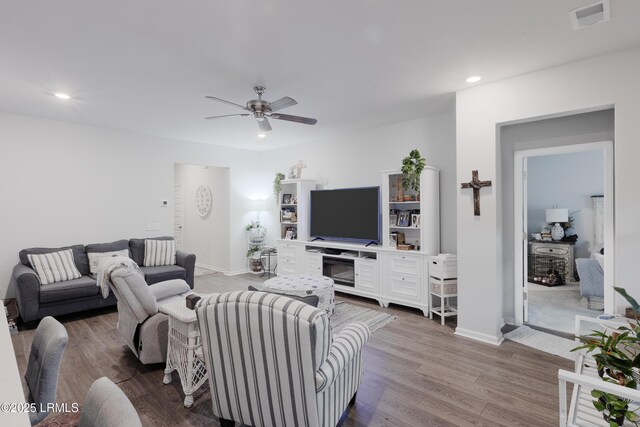 living room with light hardwood / wood-style floors and ceiling fan