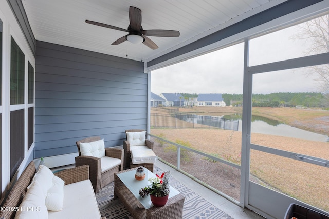 sunroom with a water view and ceiling fan