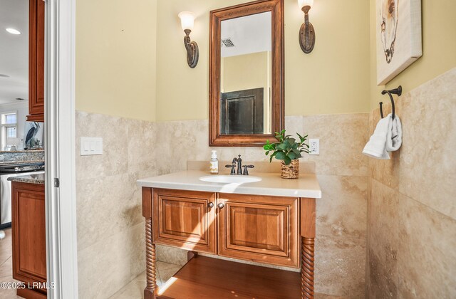 54 Battery Creek Club Dr, Beaufort, SC 29902 - bathroom with visible vents, wainscoting, tile walls, and vanity