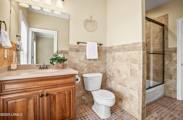 54 Battery Creek Club Dr, Beaufort, SC 29902 - bathroom with vanity, a wainscoted wall, tile walls, toilet, and combined bath / shower with glass door