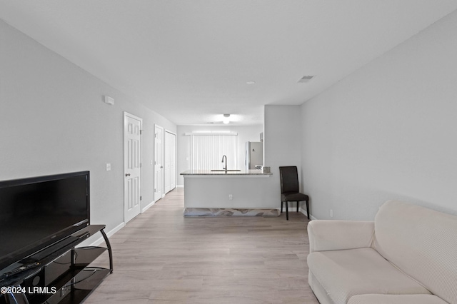 living room featuring sink and light hardwood / wood-style floors