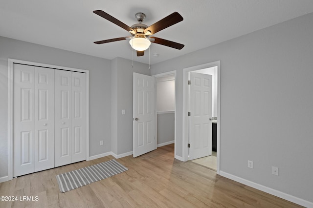 unfurnished bedroom featuring ceiling fan, light hardwood / wood-style floors, and a closet