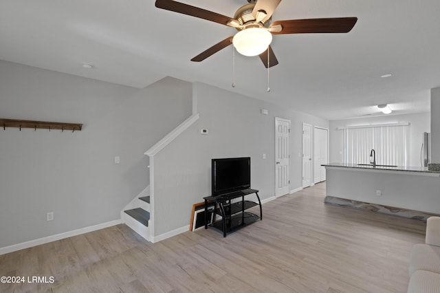 unfurnished living room featuring sink, light hardwood / wood-style floors, and ceiling fan