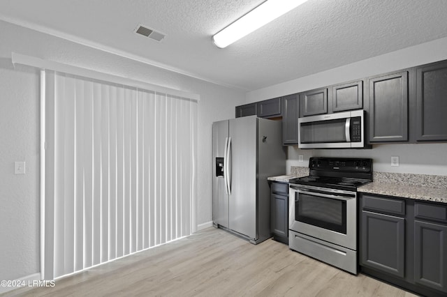 kitchen featuring appliances with stainless steel finishes, gray cabinets, and a textured ceiling