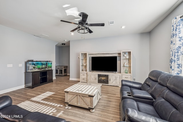 living room featuring wood-type flooring and ceiling fan