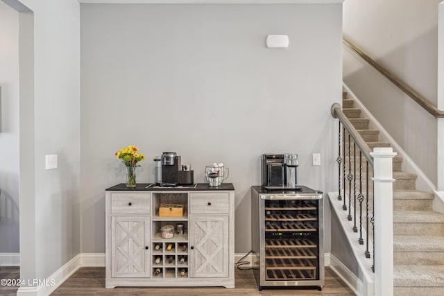 bar with hardwood / wood-style flooring and beverage cooler