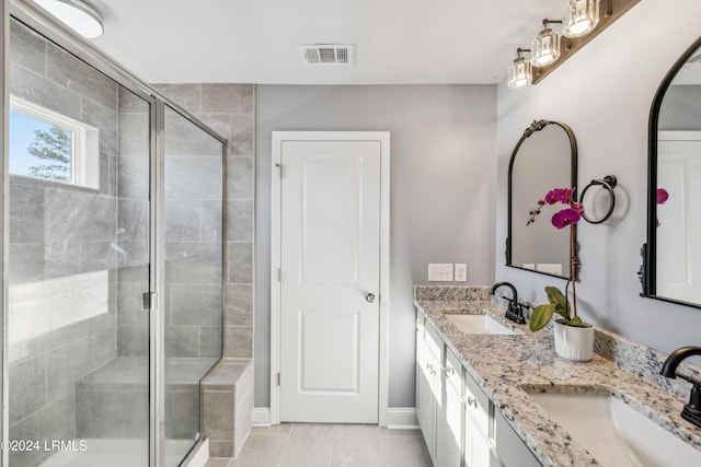 bathroom with vanity, a shower with shower door, and tile patterned floors