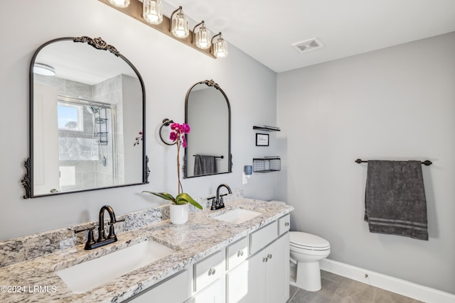 bathroom featuring a shower with door, vanity, and toilet