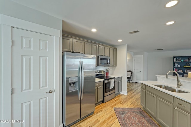 kitchen featuring recessed lighting, stainless steel appliances, light wood-type flooring, a sink, and visible vents