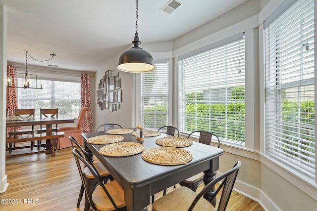dining room featuring visible vents, baseboards, a chandelier, and light wood-type flooring