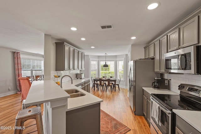 kitchen featuring a sink, appliances with stainless steel finishes, visible vents, recessed lighting, and gray cabinets