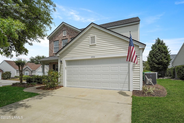 traditional-style home with cooling unit, concrete driveway, a front yard, and an attached garage