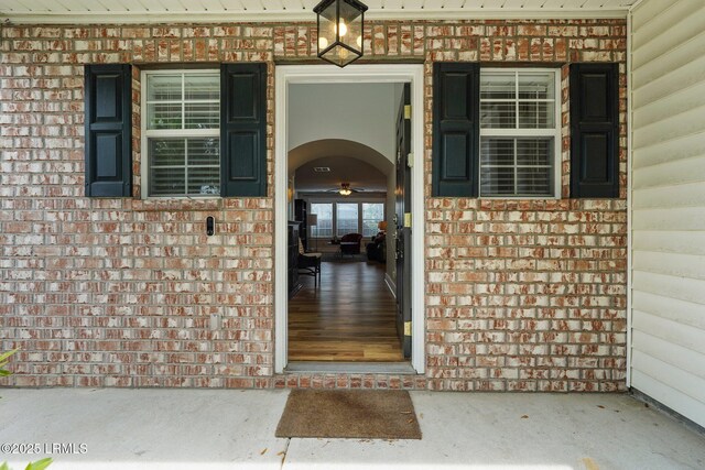 entrance to property with covered porch and brick siding