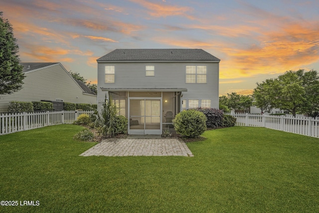 back of house featuring a sunroom, a yard, a fenced backyard, and a patio area