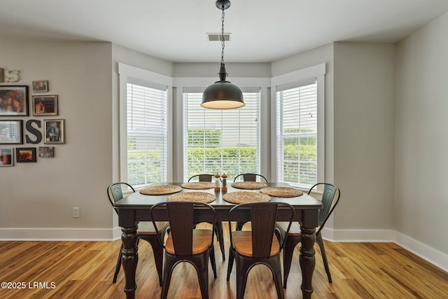 dining room featuring baseboards, visible vents, and light wood-type flooring