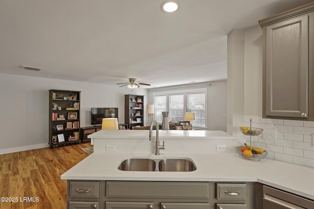 kitchen featuring a sink, visible vents, ceiling fan, open floor plan, and gray cabinets