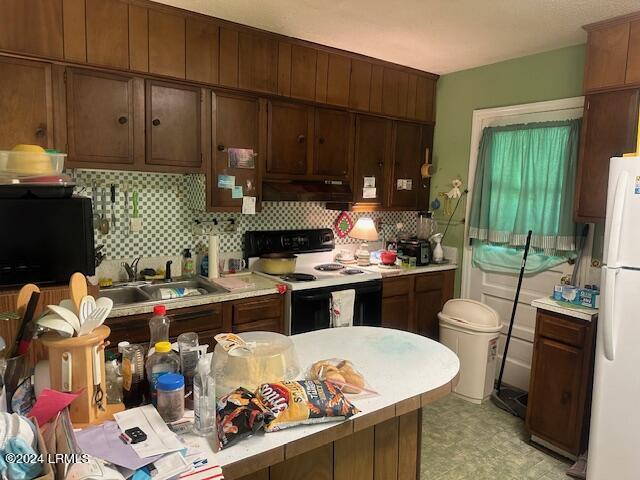8 Taylor St, Beaufort, SC 29906 - kitchen with sink, electric range oven, white refrigerator, custom range hood, and decorative backsplash