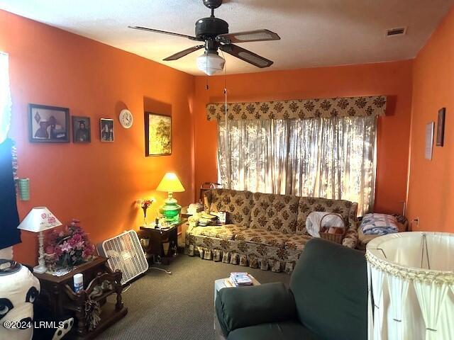 living room featuring carpet floors and ceiling fan