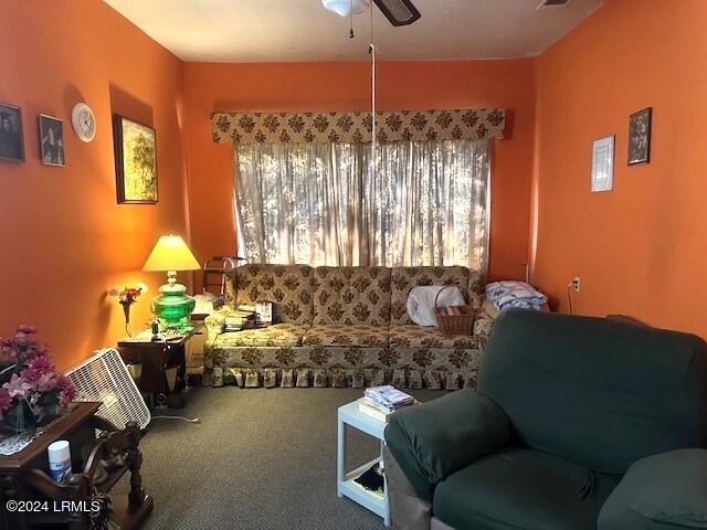 living room featuring carpet flooring and ceiling fan