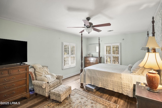 bedroom featuring dark hardwood / wood-style flooring, ornamental molding, and ceiling fan