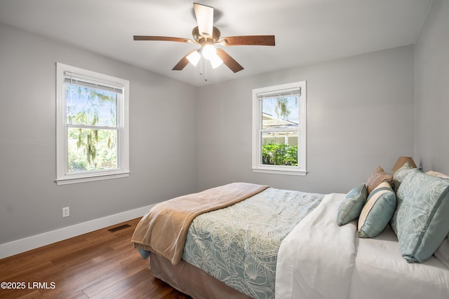 702 Center Dr W, Beaufort, SC 29902 - bedroom with multiple windows, baseboards, wood finished floors, and a ceiling fan