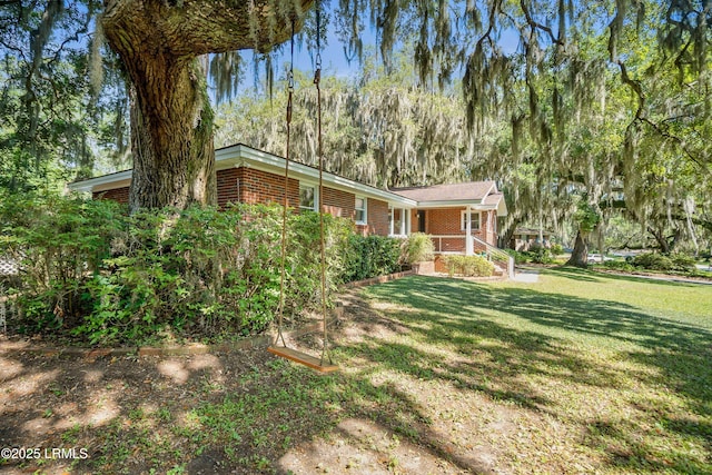 702 Center Dr W, Beaufort, SC 29902 - view of front of home featuring brick siding, a front lawn, and a porch