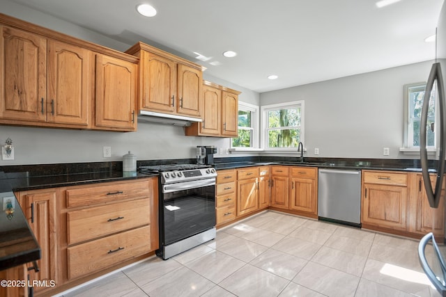 702 Center Dr W, Beaufort, SC 29902 - kitchen featuring appliances with stainless steel finishes, a sink, under cabinet range hood, dark stone counters, and recessed lighting