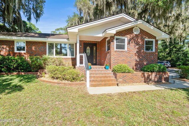 702 Center Dr W, Beaufort, SC 29902 - view of front of house featuring brick siding and a front lawn
