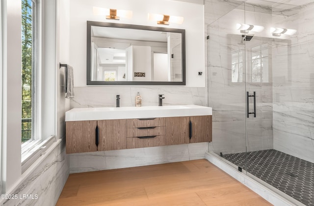 full bathroom featuring vanity, tile walls, a shower stall, and wood finished floors