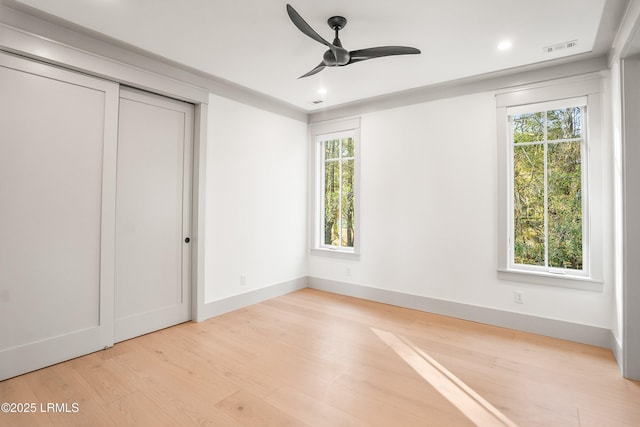 unfurnished bedroom featuring visible vents, recessed lighting, wood finished floors, and multiple windows