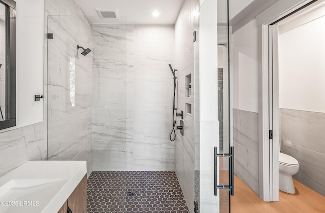 full bath featuring visible vents, toilet, tile walls, recessed lighting, and a marble finish shower