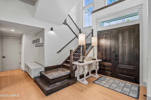 foyer featuring plenty of natural light, recessed lighting, stairs, and wood finished floors