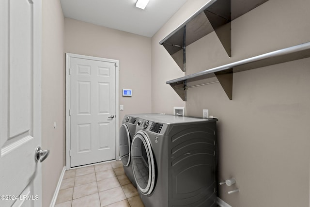 clothes washing area with light tile patterned floors and washing machine and clothes dryer