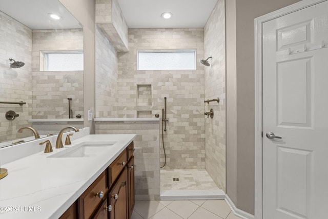 bathroom featuring vanity, tile patterned flooring, and a tile shower