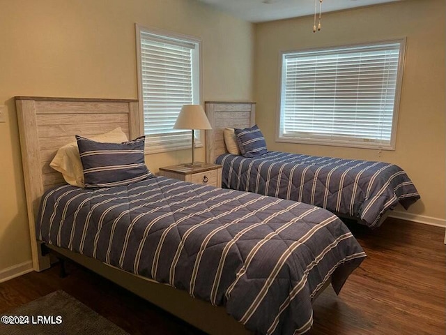 bedroom with dark wood-type flooring and multiple windows