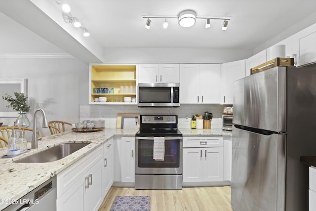 7 Three Mast Ln Unit 7, Hilton Head Island, SC 29928 - kitchen featuring stainless steel appliances, a sink, white cabinets, backsplash, and ornamental molding