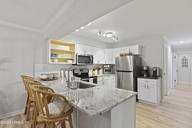 7 Three Mast Ln Unit 7, Hilton Head Island, SC 29928 - kitchen with appliances with stainless steel finishes, a peninsula, light stone counters, a breakfast bar area, and crown molding
