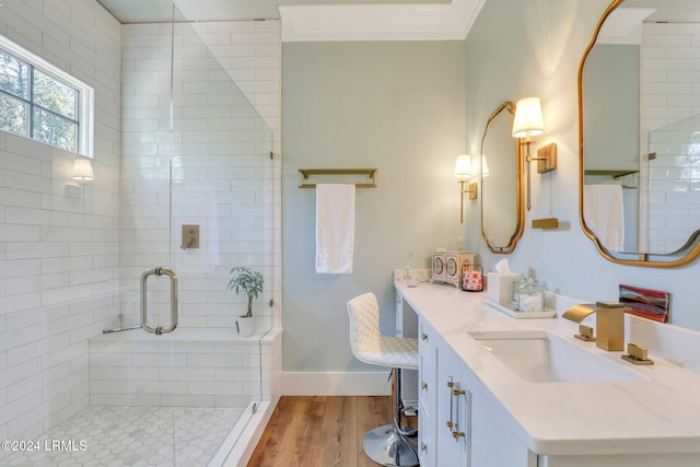 bathroom featuring walk in shower, wood-type flooring, crown molding, and vanity